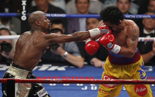 Floyd Mayweather Jr., left, hits Manny Pacquiao, from the Philippines, during their welterweight title fight on Saturday, May 2, 2015 in Las Vegas. (AP)