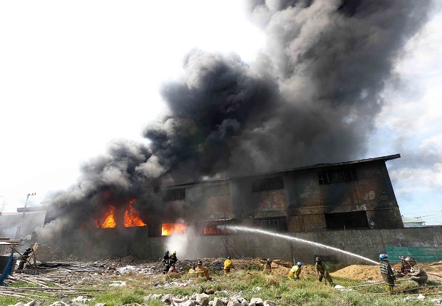 Teams of firemen struggle to put out a big fire in a factory in Brgy. Ugong, Valenzuela City. (INQUIRER FILE PHOTO/LYN RILLON)
