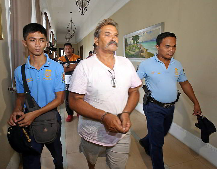 Australian Michael Refalo is escorted by police officers back to jail after being presented to Vice Gov. Agnes Magpale and representatives of the International Justice Mission (IJM) a day after his arrest. (CDN PHOTO/JUNJIE MENDOZA)