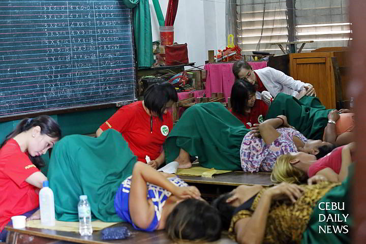 Doctors examine women who availed of the free cervical screening at the Cebu City Central School.  (CDN Photo/Junjie Mendoza)