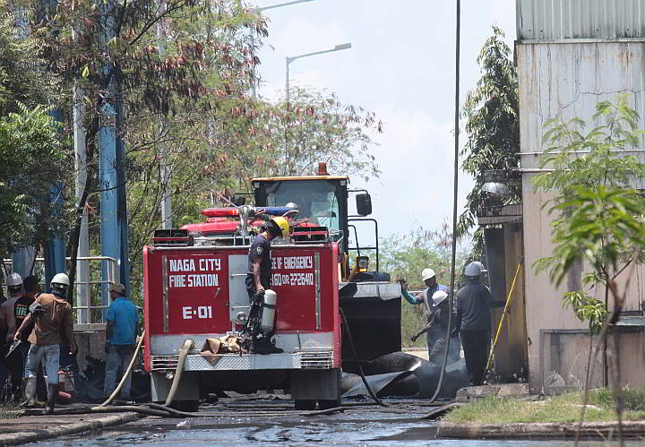 Naga City firefighters and employees of Kepco-SPC help put out the fire that hit the coal plant’s eight-story crusher building. (CDN PHOTO/ JUNJIE MENDOZA)