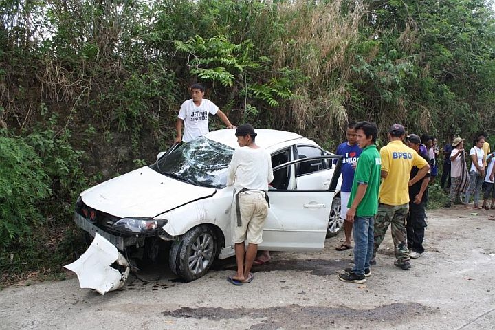 Residents check the damage car of Fr. Bernardo Oyao after the sedan flipped twice during the crash in barangay Sudlon 1, Cebu City. 