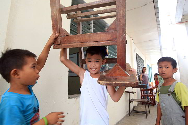 NO BURDEN. A pupil of the Cabahug Elementary School in Looc, Mandaue City lifts an armchair during the Brigada Eskwela cleanup done two weeks ahead of the opening of classes.  (CDN PHOTO/TONEE DESPOJO)