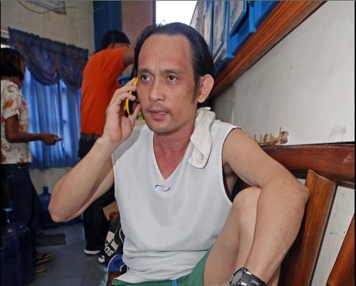 Richard Fhidel Suico answers a phone call at the Pardo Police Station where he was detained for attacking his neighbor with a knife.