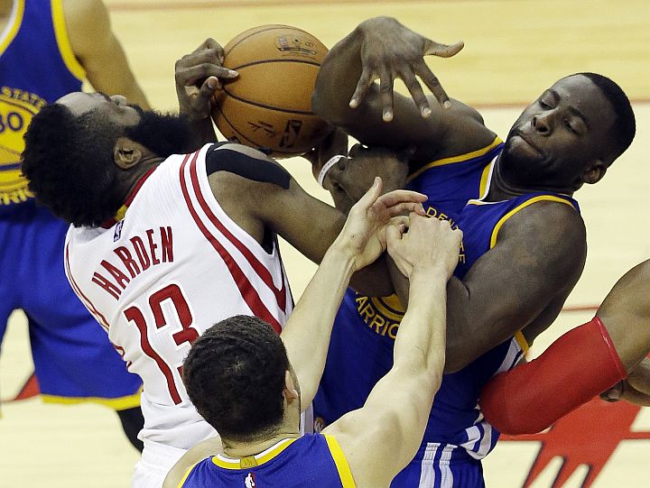 Houston Rockets guard James Harden (13) and Golden State Warriors forward Draymond Green (23) grapple for the ball as guard Klay Thompson (11) reaches in during the second half in Game 4 of the NBA basketball Western Conference finals.