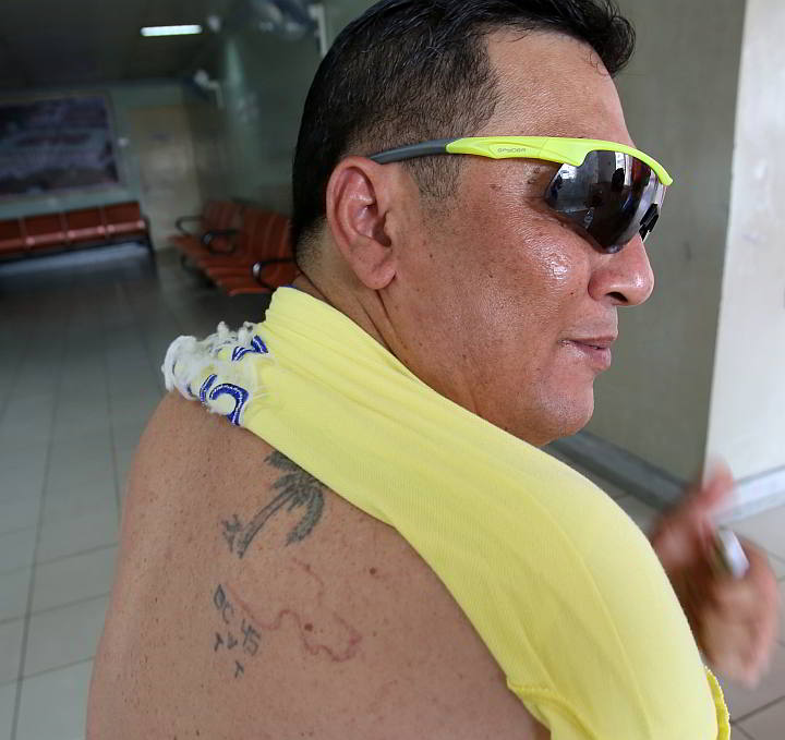 Marco Toral, provincial jail consultant of the Cebu Provincial Detaintion and Rehabilitation Center (CPDRC), rolls up his shirt to show proof of his seven years behind bars: his “BC .45” tattoo for Batang Cebu .45 inked by fellow inmates.  (CDN PHOTO/JUNJIE MENDOZA)