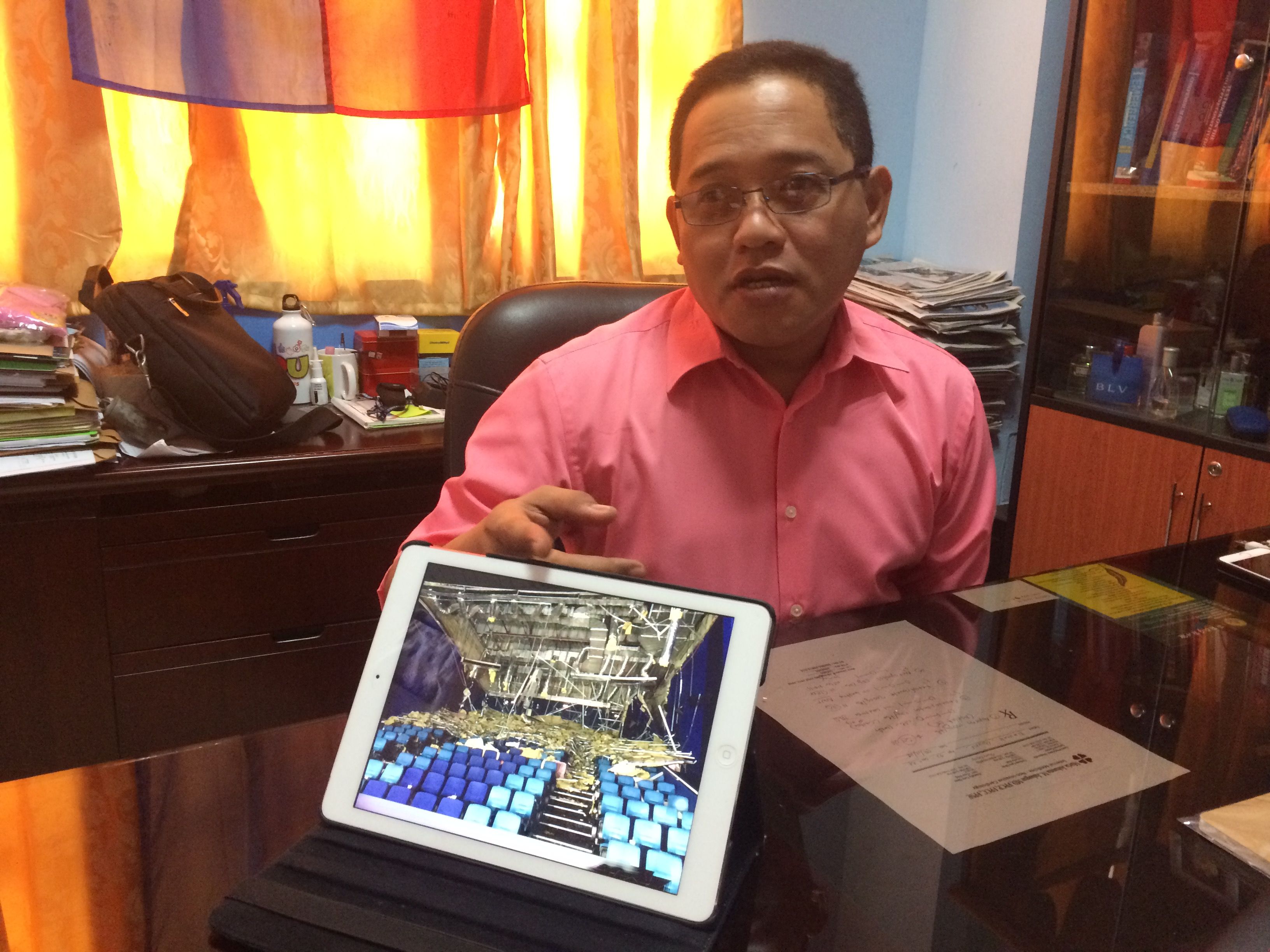 Dave Tumulak of the disaster office of Cebu City shows on his tablet a photo of the interior of the Cinema 5 after the collapse of part of the ceiling.(CDN/Santino Bunachita)