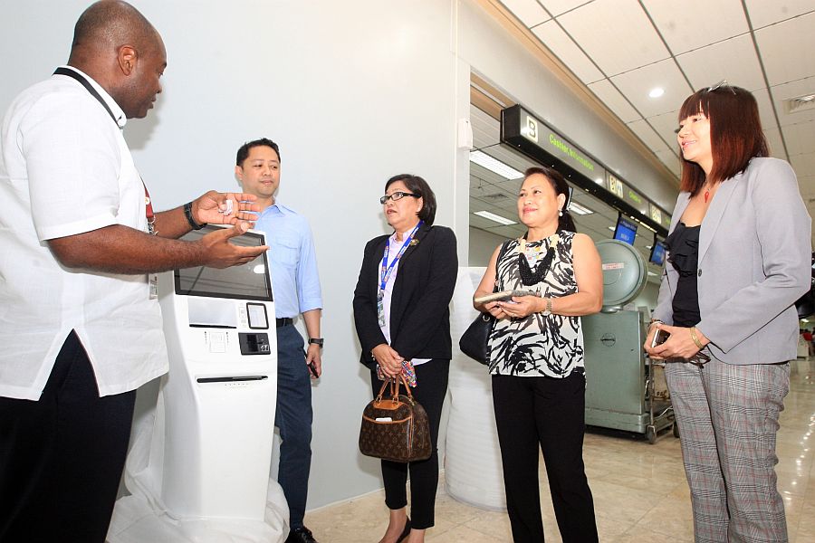 Andrew Acquaah Harrison, chief executive advisor of GMR Megawide, (left photo, right and above photo, left) shows tourism stakeholders led by Rowena Montecillo, Department of Tourism regional director (above, second from right), and Ma. Teresa Chan, Cebu Chamber of Commerce and Industry President(above, right), the new X-ray machines(left photo) and the self-service kiosk.(CDN/TONEE DESPOJO)