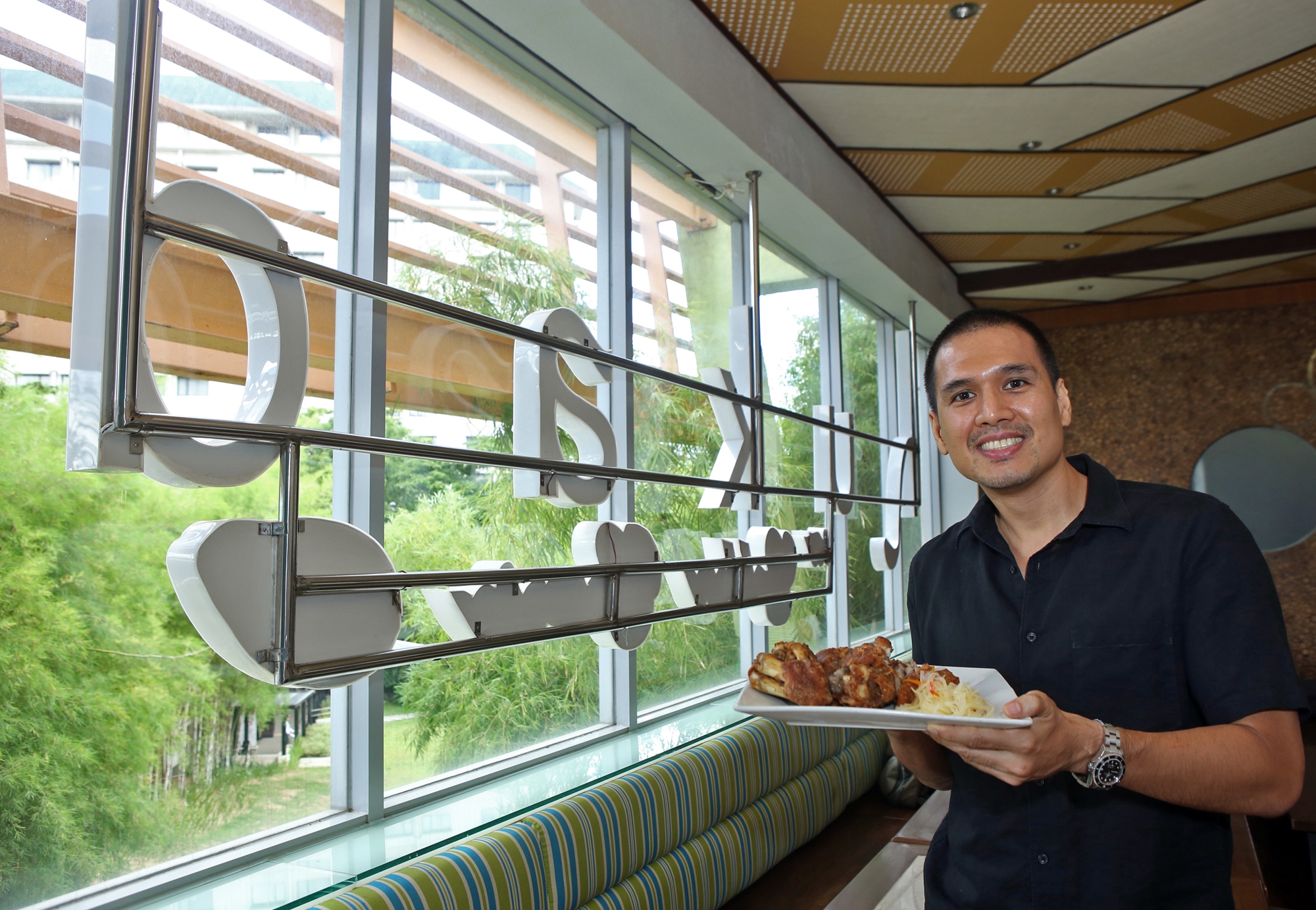 Kenneth Kokseng, general manager of Golden Cowrie and Hukad Restaurants, shows their crispy pata, one of the restaurant's popular dishes.(CDN/LITO TECSON)