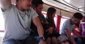 Students, beware! An unidentified man drops some coins on board a jeepney to distract would-be-victims in this screen grab from Youtube. 