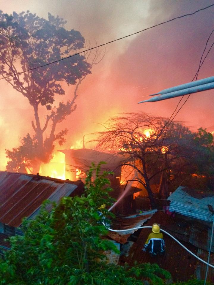Fireman train their hose on burning houses in barangay Mambaling, Cebu City.(CDN/ TONEE DESPOJO)