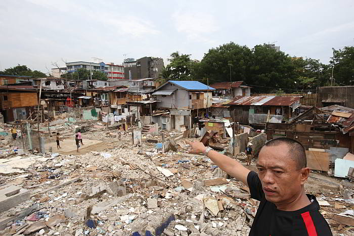 A resident (top photo) points to  part of the contested lot. (CDN PHOTO/ JUNJIE MENDOZA)