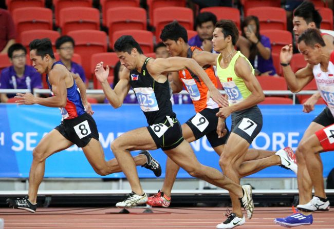 Filipinos Jesson Ramil Cid (No. 6 center in black) and Janry Ubas (No. 8) compete in the 100-meter event of men's decathlon in the 28th SEA Games at the National Stadium in Singapore.(INQUIRER)