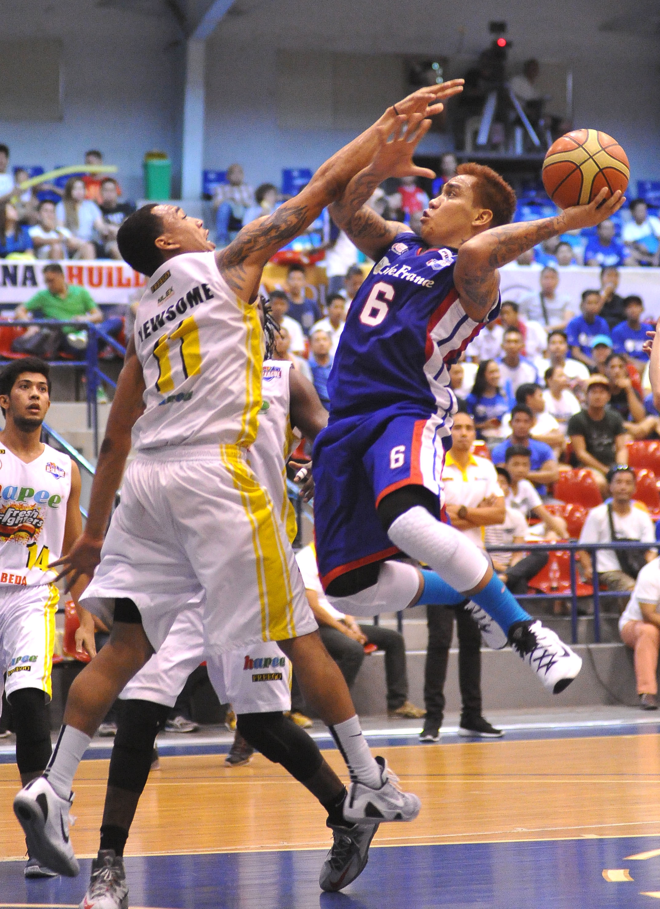 Cebuano Eluid Poligrates of Cafe France tries to put up a shot against Cris Newsome of Hapee Fresh.(INQUIRER)