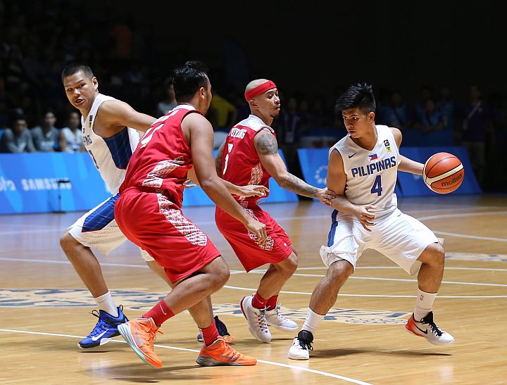 The Philippines' Kiefer Ravena tries to get pass two Indonesian defenders in the championship games of men's basketball at the 26th SEA Games at the OCBC Arena Hall 1 of the Singapore Sports hub.  