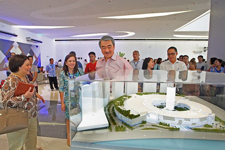 Hans Sy (middle), SM Prime Holdings president, and Marissa Fernan (left), vice president, view a scale model of SM seaside complex.
