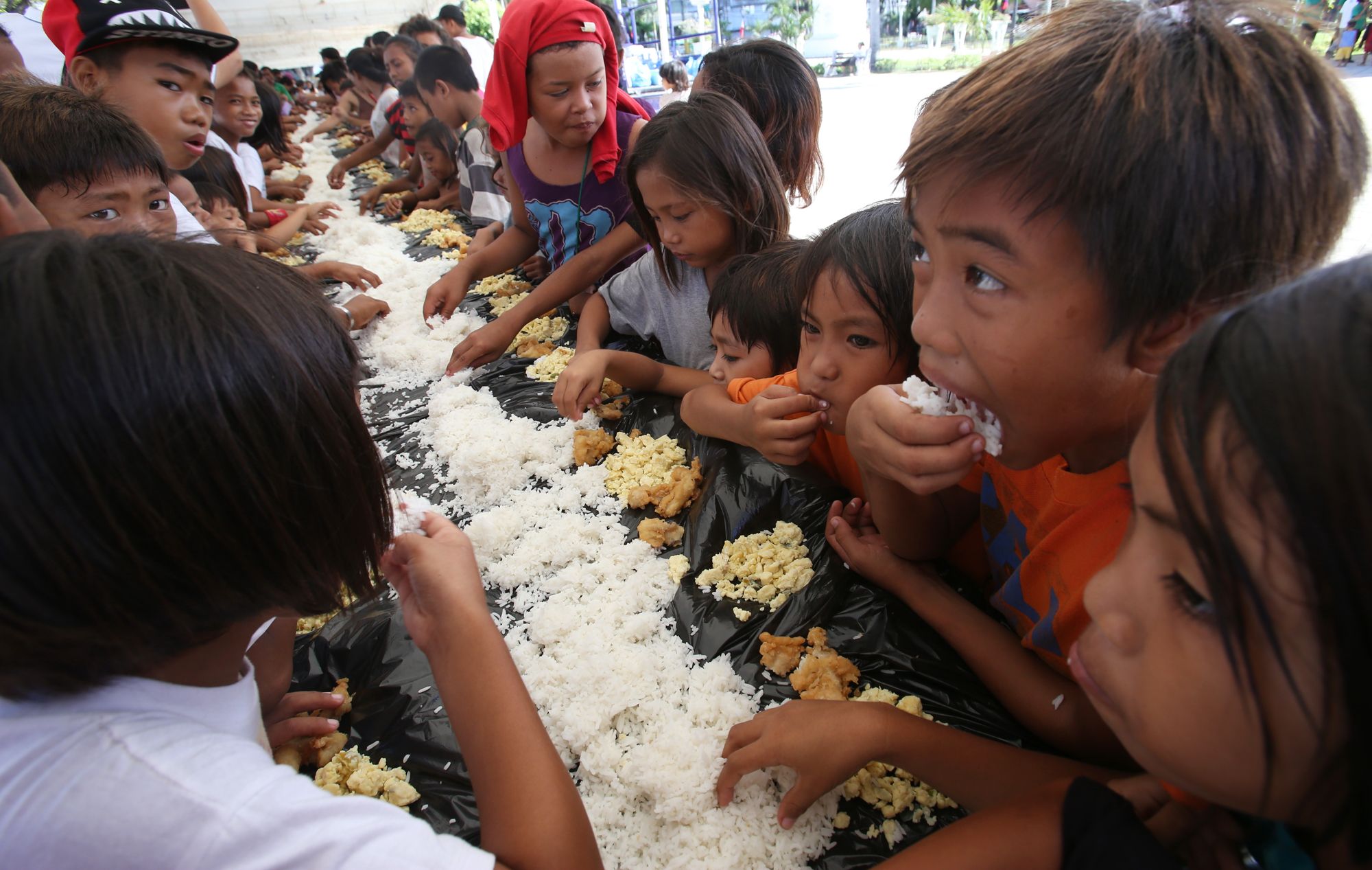 More than a 100 street children share a "boodle fight" meal in Plaza Independencia for the launch of anti-hunger campaign by volunteers of Kuogos Alliance of Cebu.(CDN/JUNJIE MENDOZA)