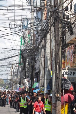Passengers and students wait for jeepneys under dangling wires hanging overhead Sanciangco street, barangay Kalubihan, Cebu City. (CDN PHOTO/ JUNJIE MENDOZA) 
