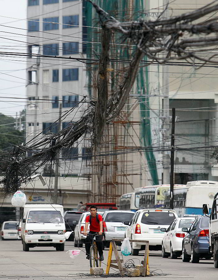 A mess of low hanging wires in Escario Street  like this scene in  2011 still poses safety issues in  parts of Cebu City.   (CDN FILE PHOTO)