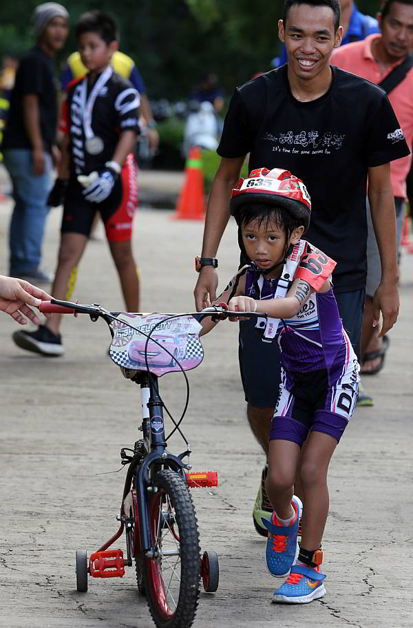 This young participant prepares to mount  his bike equipped with balancers  during yesterday’s  Alaska Ironkids race at the Shangri-la's Mactan Resort and Spa. (CDN PHOTO/ JUNJIE MENDOZA)