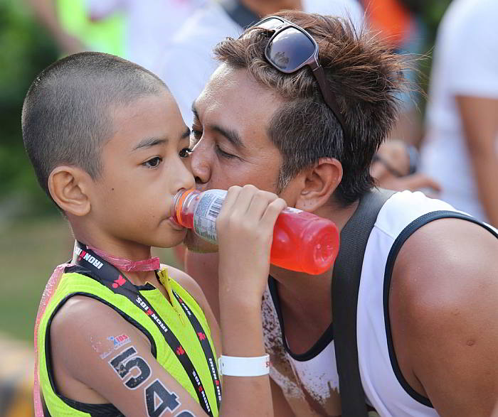 Former motocross racer  Eugene Faelnar kisses his son Eugene Faelnar III (549) after the latter completed the race in the 9-10 age category. (CDN PHOTO/ JUNJIE MENDOZA)