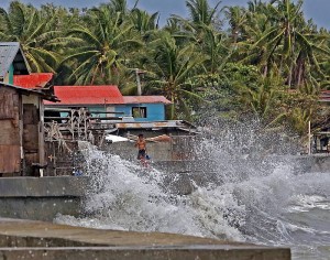 NO MOVING OUT. Settlers staying along a seawall in sitio Mahayahay, barangay Cansojong, Talisay City watch the waves crash near their homes as they remain determined to wait it out until the weather clears.(CDN/LITO TECSON)