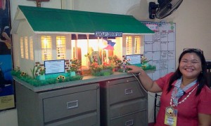 Cabancalan Elementary School principal Ma. Divina Flores points to the scale model of a newly rewired school building. (CDN/NORMAN MENDOZA)