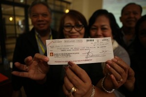 A check for P1 billion is held up by Acting City treasurer Diwa Cuevas (center), the 10 percent security deposit of the SM-Ayala consortium whose joint bid surprised everyone. Ayala Land, Inc. vice president Aniceto Bisnar Jr. (above, right) and SM Prime vice president Ronald Tumao said it made sense for the two property giants to work together.(CDN/LITO TECSON)