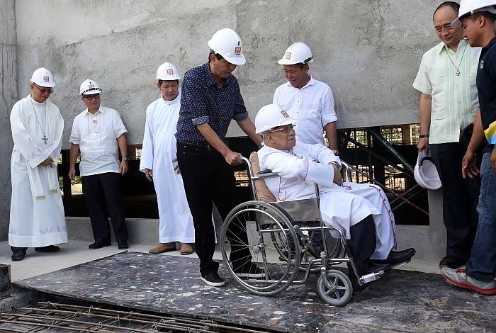 Cebu City Mayor Michael Rama guides the wheelchair of  Archbishop Emeritus Ricardo Cardinal Vidal during the  topping-off ceremony of the Eucharistic Pavilion in Mabolo, Cebu City. (CDN Photo/Junjie Mendoza)