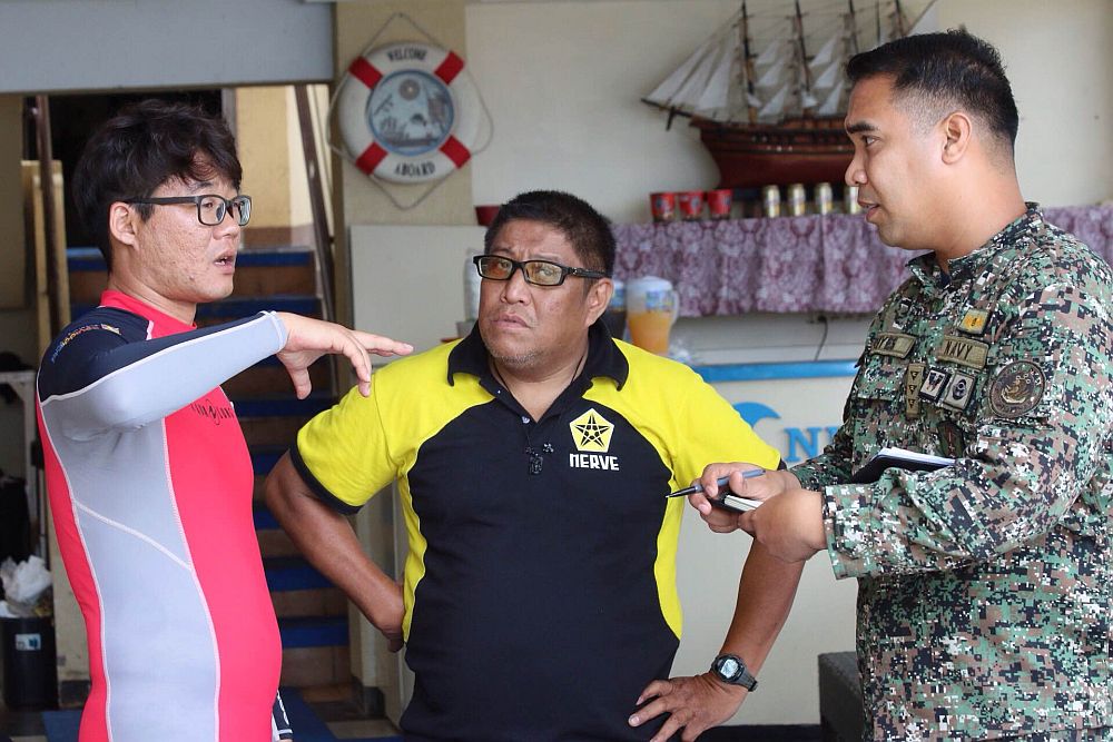 A volunteer Korean diver discusses search plans with Lt.  James Reyes of the Navy and  Andy Berame, Lapu-Lapu city disaster chief.(CDN/NORMAN MENDOZA)