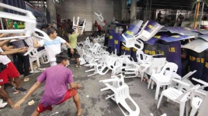 Supporters of Makati Mayor Junjun Binay throw chairs at policemen in a clash at the Makati City Hall as authorities try to enforce the suspension order on Binay. (INQUIRER)
