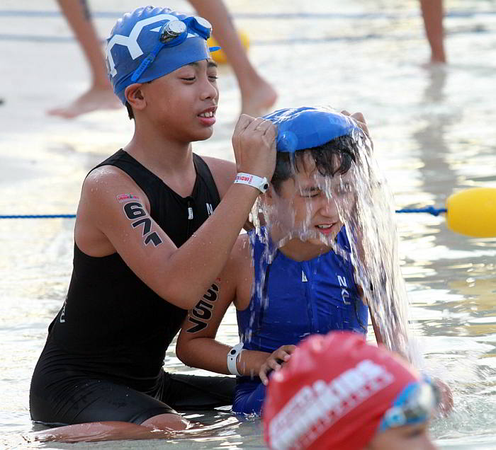Samuel Christopher Visarra (left) helps his younger brother Lawrence Andrew with his swim cap before starting the race.