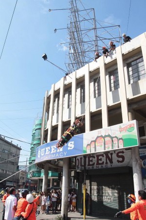 A man is lowered down from the scaffolding he climbed in downtown Cebu City last Wednesday. (CDN PHOTO/JUNJIE MENDOZA)