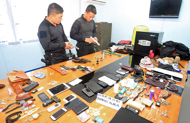  TWO police members of the Special Weapon and Tactics (SWAT) check valuables recovered from armed men who robbed businessman Victoriano Pagador in his house in Gemsville Subdivision, barangay Lahug, Cebu City. (CDN/TONEE DESPOJO)