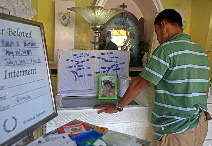 Edmund Boreros views the remains of his 13-year-old son Ralph Bureros inside a chapel in barangay Tinago.  (CDN PHOTO/LITO TECSON)