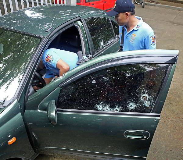 Talisay City policemen check the Nissan sentra who were ambush in Barangay Lawaan Talisay City that killed 2 person and injuring one.