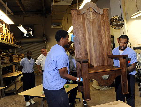 Inmates Rameen Perrin (left) and Evan Davis work on a chair carved out of walnut for Pope Francis to use during his planned visit next month at the  Curran-Fromhold Correctional Facility in Philadelphia.  (AP Photo)