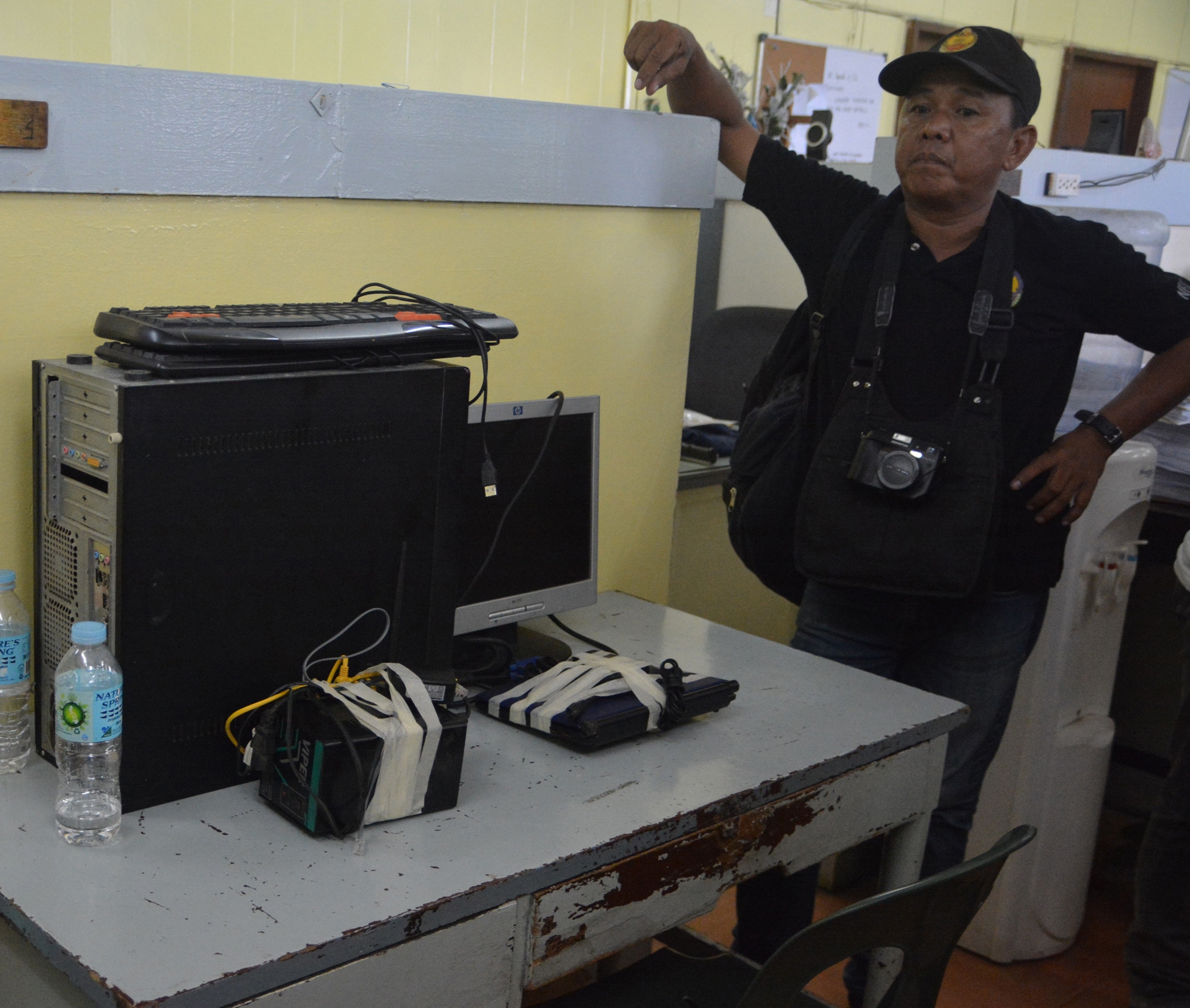 An NBI Operative watches over the Computer Unit confiscated at the house of Editha Aying in Soong, Lapu-Lapu City. (CDN PHOTO/CHRISTIAN MANINGO)