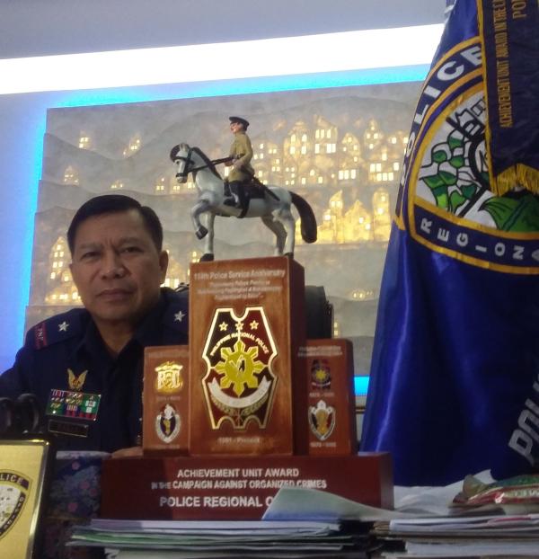Chief Supt. Prudencio Banas shows the trophy and streamer given to the Police Regional Office 7 as best police regional office in the country. (CDN PHOTO/ APPLE TAAS)