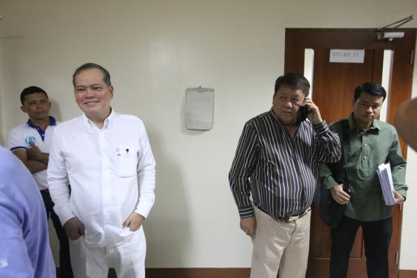 Broadcaster-columnist Bobby Nalzaro appears relaxed while former Cebu City mayor Tomas Osmena takes a call before attending a court hearing. (CDN PHOTO/ JUNJIE MENDOZA)