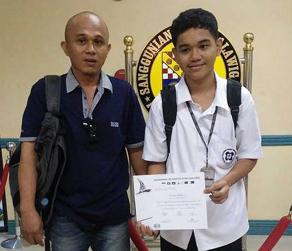 Student Barly Dinalo shows  his certificate from the International Mathematics Wizard Competition held in Hong Kong. He was accompanied by  his father (left) to  the Cebu  Provincial Board’s session hall where the boy was honored.  (CDN PHOTO/VICTOR ANTHONY V. SILVA)