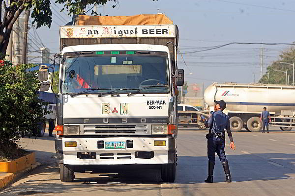 A traffic personnel stops a truck driver passing along S. Osmeña Road early in the morning in this file photo.