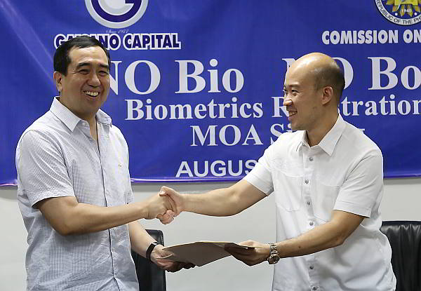 Comelec chairman  Andres Bautista (left)  exchanges documents with Yongson Huan, Gaisano Capital Group  finance manager, after signing an  agreement for Gaisano Capital mall branches to be used as venues for voter’s biometrics  registration. (CDN Photo/Junjie Mendoza)