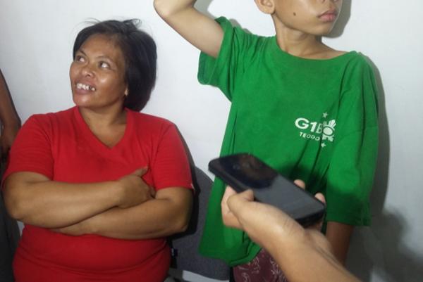 Dyna Felices Quan talks to reporters at the police station after she was arrested with the boy beside her for stealing a businessman's bag containing P150,000. The boy, who was arrested several times in the past, is not her son but has been staying with her for two years, police said. (CDN PHOTO/ APPLE MAE TAAS)