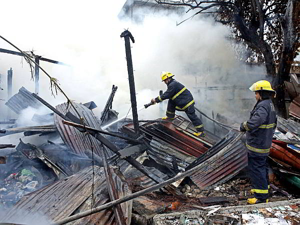 Fire fighters put off the fire that displaced 13 families in barangay Mabolo, Cebu City yesterday. CDN PHOTO/LITO TECSON)