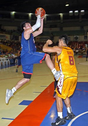 Jan Auditor of the SWU Cobras goes up for a shot against Mark Christian Kong of CIT-U in yesterday’s Cesafi seniors’ game at the Cebu Coliseum. (CDN PHOTO/LITO TECSON)
