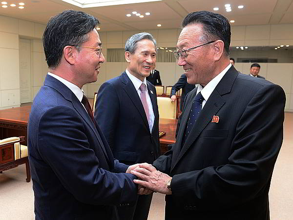 South Korean Unification Minister Hong Yong-pyo, left, shakes hands with Kim Yang Gon, a senior North Korean official responsible for South Korean affairs, as South Korean presidential security adviser Kim Kwan-jin looks on after their meeting at the border village of Panmunjom in Paju, South Korea. (AP Photo)