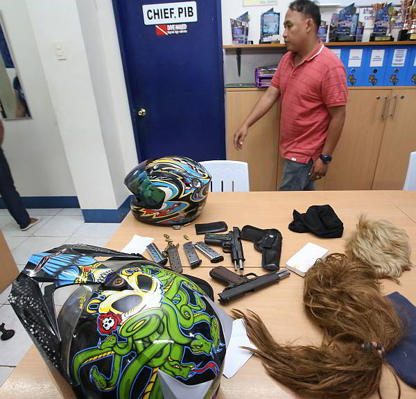 Firearms, wigs and other items were seized from Jelson Enriquez (inset) who was tagged by his brother as the one who masterminded the robbery of four Chinese tourists in Medellin town, Cebu. (CDN PHOTO/ JUNJIE MENDOZA)