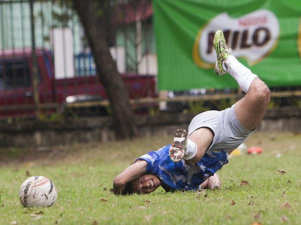 A PAREF Springdale booter falls to the ground after missing the ball during their championship match against Don Bosco at the La Paz Football Field in Iloilo City. 