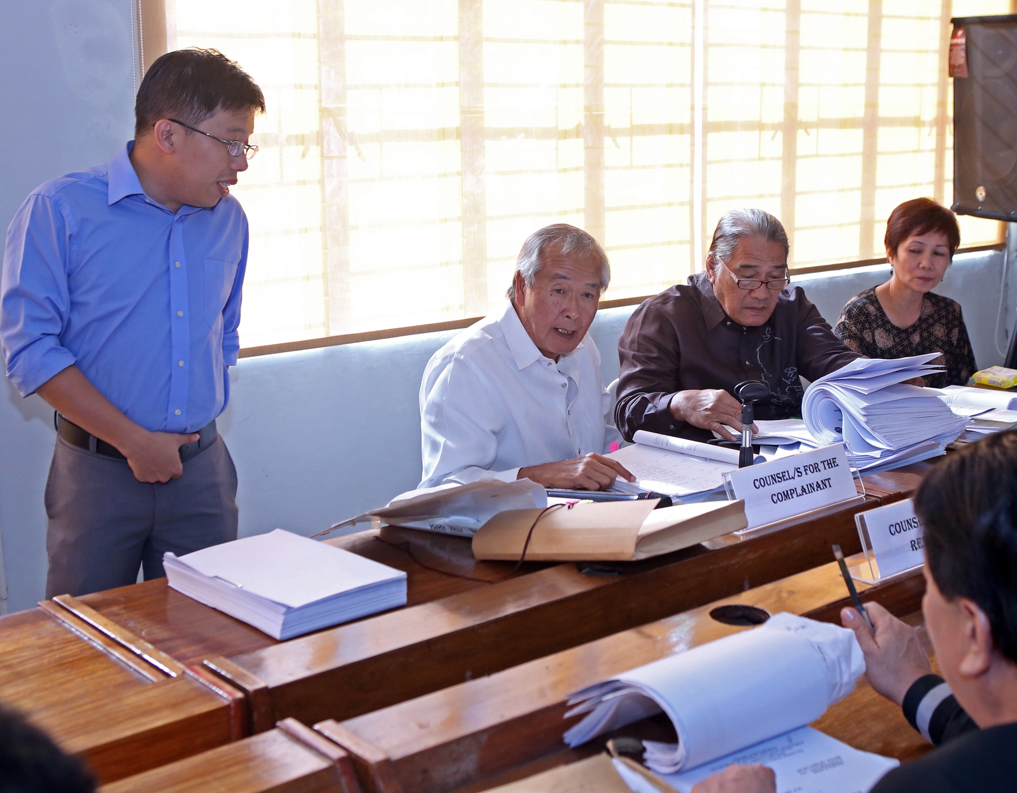 Lawyer Reymelio Delute (right) looks over his files while co-counsel Ben Militar answers questions during a hearing by the DILG in Cebu City on the issue of 2013 calamity aid released by City Hall. (CDN PHOTO/ LITO TECSON)